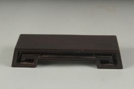 A CHINESE CARVED HARDWOOD STAND - POSSIBLY ZITAN, 13cm long.
