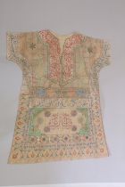 AN ISLAMIC TALISMANIC SHIRT, hand painted with calligraphic panels and cartouches.