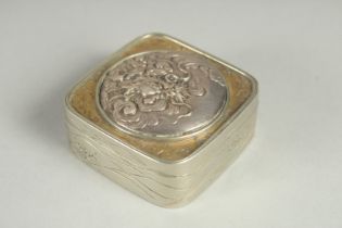 A SMALL SIGNED JAPANESE WHITE METAL AND BRASS BOX, the hinged lid with relief dragon roundel, 5cm