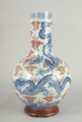 A CHINESE UNDERGLAZE RED AND BLUE PORCELAIN DRAGON VASE ON HARDWOOD STAND, painted with three