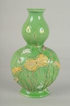 AN EARLY 20TH CENTURY CHINESE GREEN GROUND DOUBLE GOURD WALL VASE, with relief decoration, 21cm
