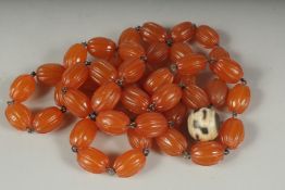 AN EARLY 20TH CENTURY AMBER BEADED NECKLACE AND DZI BEAD, (2).