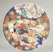 A LARGE 19TH CENTURY JAPANESE IMARI PORCELAIN CHARGER, enamel painted with a scene of seated