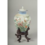 A SMALL CHINESE REPUBLIC PERIOD PORCELAIN JAR AND COVER, on a fitted wooden stand, painted with