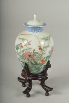 A SMALL CHINESE REPUBLIC PERIOD PORCELAIN JAR AND COVER, on a fitted wooden stand, painted with