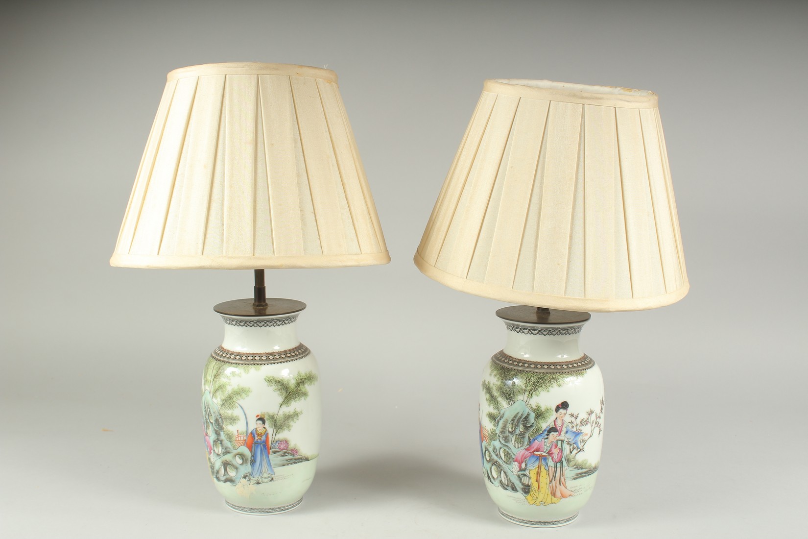 A PAIR OF CHINESE FAMILLE ROSE PORCELAIN VASE LAMPS, each painted with figures in a garden and