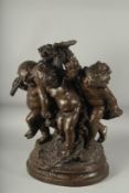 H. MOREAU A GOOD BRONZE OF THREE CUPIDS depicting grape harvest, on a circular base. Signed. 20ins