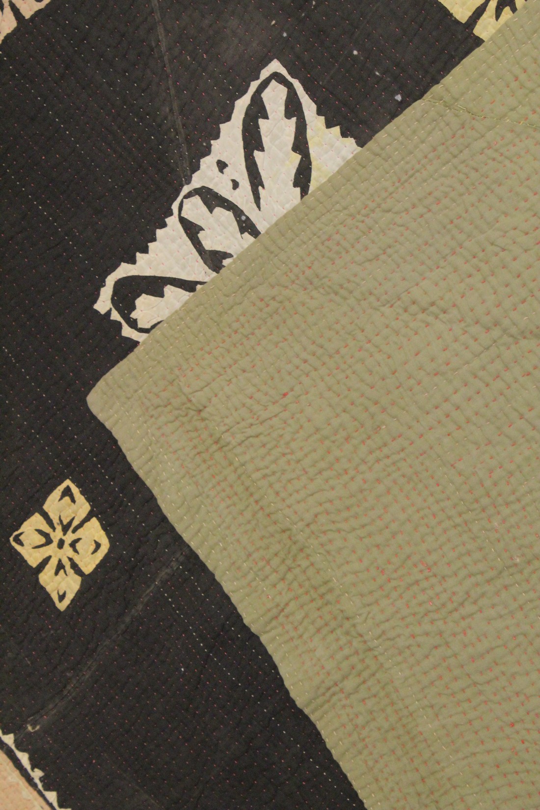 A QUILTED BEDSPREAD black ground with geometric designs. 7ft 4ins x 4ft 4ins. - Image 3 of 3