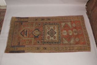 A PERSIAN RUG, rust ground with geometric stylised decoration. 7ft 7ins x 3ft 11ins.
