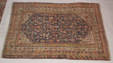 A PERSIAN RUG dark blue ground with stylised decoration. 7ft x 4ft 7ins.