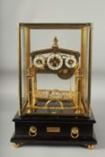 A GOOD ROLLING BALL CLOCK with three dials in a glass case. 16ins high overall.
