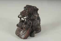 A BLACK FOREST CARVED WOOD DOG carrying three puppies in a basket, formed as an inkwell. 4.5ins