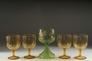A LARGE ARMORIAL GREEN GOBLET, 8ins high and four plain amber goblets (5).