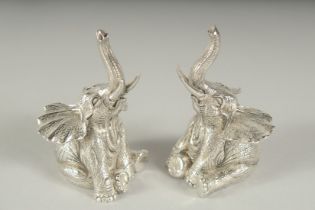 A PAIR OF .800 SILVER PLATED SEATED ELEPHANTS SALT AND PEPPERS. 7cm high.