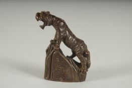 A JAPANESE BRONZE TIGER on a rock. Signed. 2ins high.