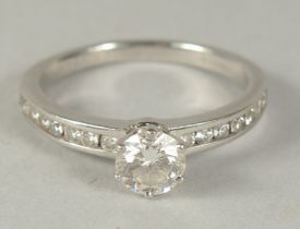 A TIFFANY & CO. PLATINUM AND SINGLE STONE DIAMOND RING with seven small diamonds on the shoulder.