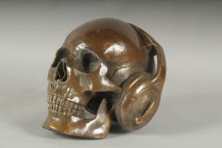 A BRONZE SKULL wearing headphones. 7ins high.