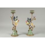 A GOOD PAIR OF PORCELAIN AND GILDED METAL BIRD CANDLESTICKS on circular bases. 13ins high.