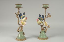 A GOOD PAIR OF PORCELAIN AND GILDED METAL BIRD CANDLESTICKS on circular bases. 13ins high.