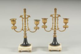 A GOOD PAIR OF ORMOLU TWO LIGHT CANDLESTICKS on square marble bases. 11ins high.