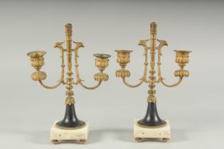 A GOOD PAIR OF ORMOLU TWO LIGHT CANDLESTICKS on square marble bases. 11ins high.