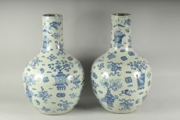 A PAIR OF CHINESE BLUE AND WHITE VASES decorated with emblems. 22ins high.