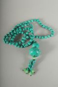 A STRING OF 100 SMALL TURQUOISE BEADS and a pendant.
