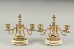A GOOD PAIR OF ORMOLU TWO LIGHT CANDLESTICKS on shaped marble bases. 8ins high.