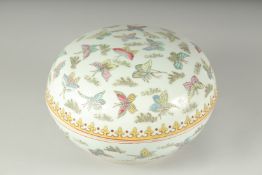 A LARGE CIRCULAR BOWL AND COVER decorated with butterflies. 10ins diameter.