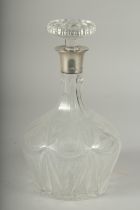 A HEAVY CUT GLASS DECANTER AND STOPPER with silver band.