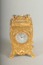 A SMALL GILDED CARRIAGE CLOCK with blue and white Roman numerals and carrying handles. 7cm high.