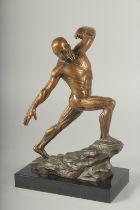 A SUPERB BRONZE ANATOMICAL MAN STANDING ON A ROCK, on a black marble base. 11ins high.