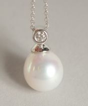 AN 18CT GOLD PEARL AND DIAMOND PENDANT on a chain in a box.