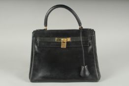 A GENUINE HERMES BLACK LEATHER KELLY BAG. 11.5ins long, 9ins high with leather handles and brass