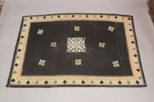 A QUILTED BEDSPREAD black ground with geometric designs. 7ft 4ins x 4ft 4ins.