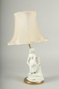 A WHITE PORCELAIN YOUNG LADY LAMP with a shade.