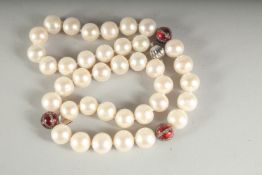 A STRING OF 38 PEARLS AND THREE DIAMOND AND ENAMEL BEADS.
