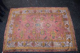A LARGE AFGHAN CARPET rust ground with stylised decoration 13ft 6ins x 10ft 4ins.