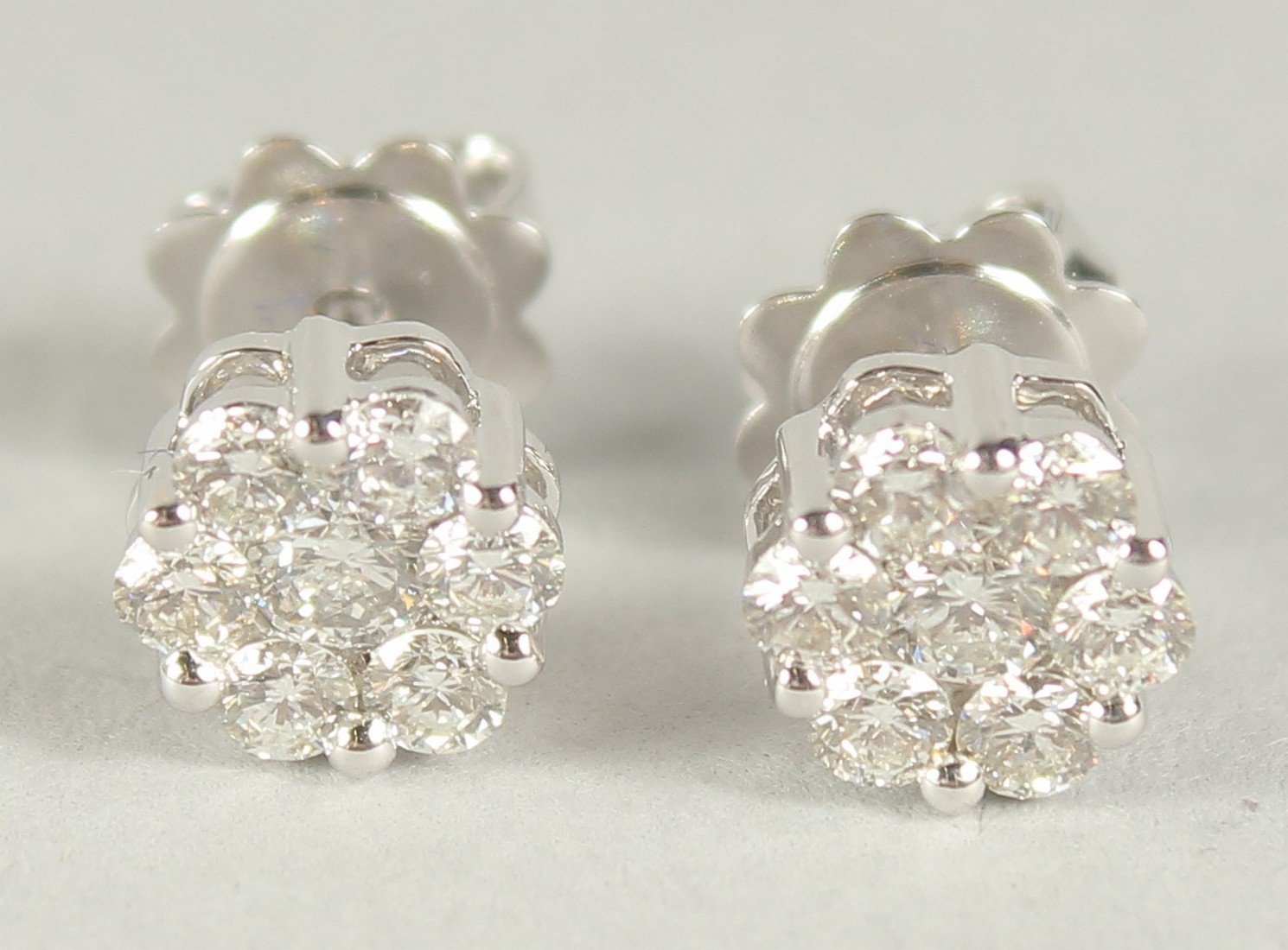 A PAIR OF 18CT WHITE GOLD DIAMOND CLUSTER EAR STUDS, approx. 1ct, in a box.