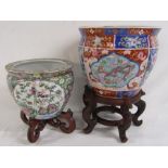 2 Oriental design jardinières on wooden stands - larger one measuring approx. 25.5cm tall (without