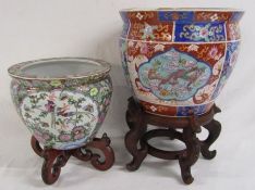 2 Oriental design jardinières on wooden stands - larger one measuring approx. 25.5cm tall (without