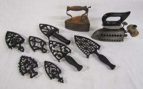 Collection of flat iron stands - trivets one marked FW London, flat iron still with brick and a