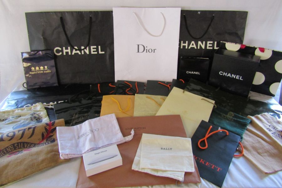 Collection of used shopping bags and boxes including Chanel, Dior, Jimmy Choo, Louis Vuitton,