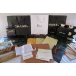 Collection of used shopping bags and boxes including Chanel, Dior, Jimmy Choo, Louis Vuitton,