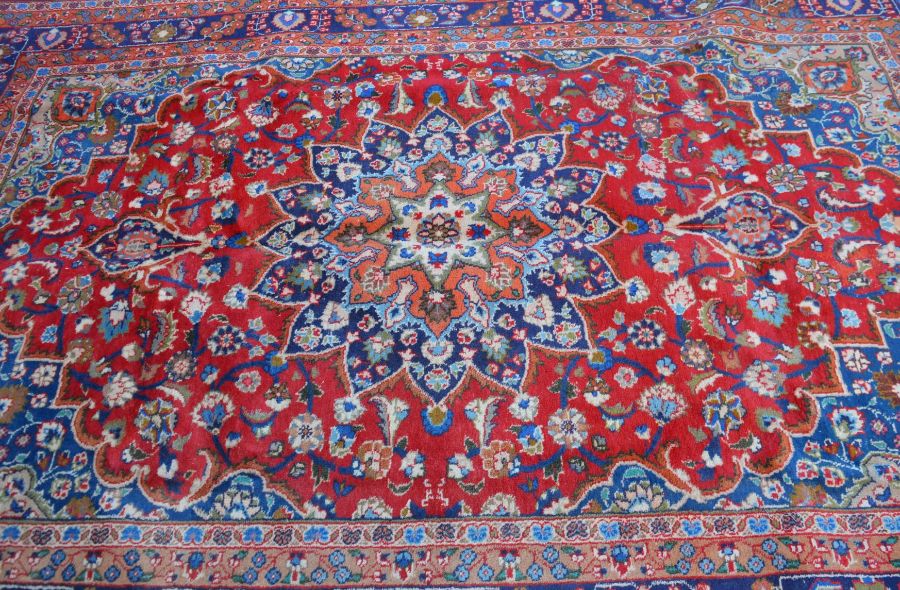 Red ground Persian Mashad carpet with floral medallion 302cm by 195cm - Image 2 of 3