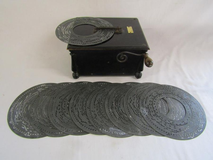 Ebonised wood Intona organette music player with plaque The Saxon Trading Co with 9 metal discs -
