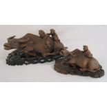 Pair of carved wood water buffalo with figures on their back with stands largest approx. 29cm