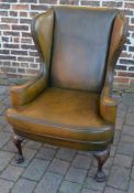 Leather wing back armchair with ornately carved front legs on hairy paw feet