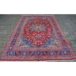 Red ground Persian Mashad carpet with floral medallion 302cm by 195cm