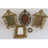 Cast metal picture frames with hinged stands and a wooden gilded frame with cherubs design